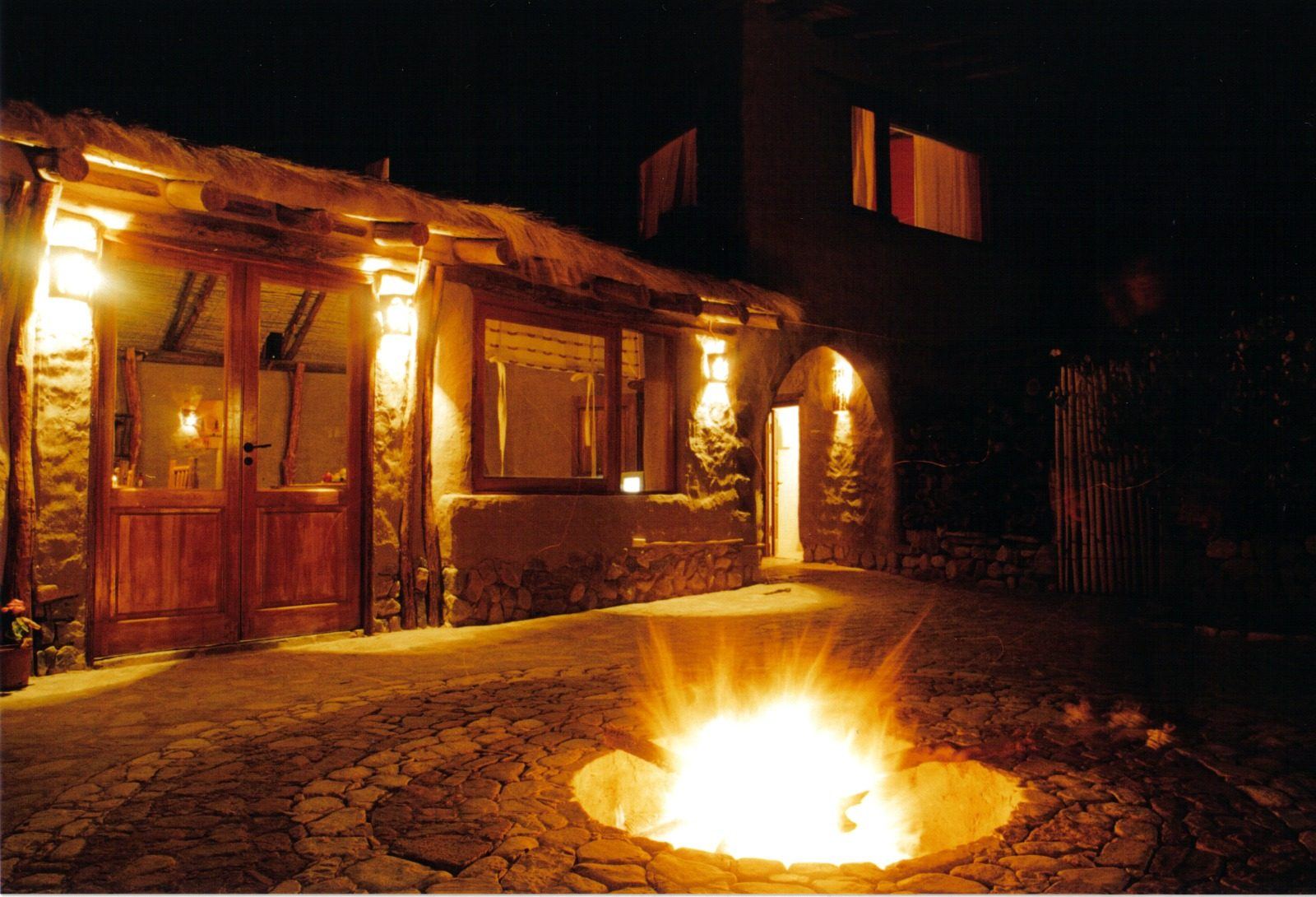 Patio del puco del Refugio del Pintor de noche, con el fogón encendido